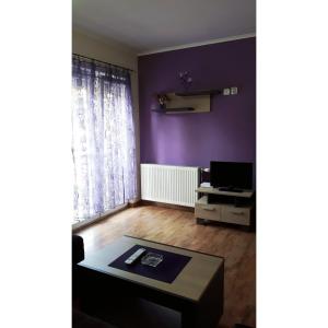 sala de estar con paredes de color púrpura y mesa de centro en Apartmani Radoičić, en Jošanička Banja