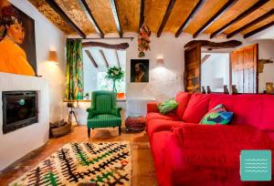 sala de estar con sofá rojo y silla verde en VILLA TOSCANA, en Benissa