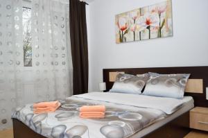 a bedroom with a bed with orange towels on it at Gamma Group Accommodation in Bucharest