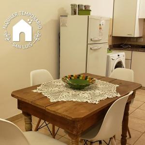 una cocina con una mesa de madera con un tazón. en Alquiler Temporario San Luis en San Luis