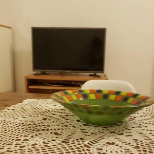 un tazón verde sentado en una mesa con TV en Alquiler Temporario San Luis en San Luis