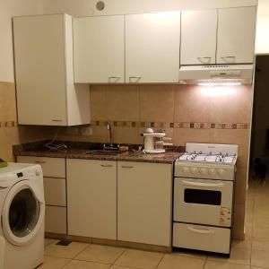 a kitchen with white cabinets and a washing machine at Alquiler Temporario San Luis in San Luis