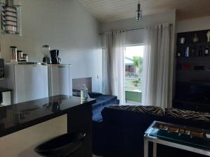 ein Wohnzimmer mit einer blauen Couch und einer Küche in der Unterkunft Flat Particular Adeias das Aguas Park Resort in Barra do Piraí