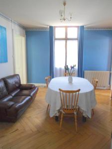 a living room with a table and a leather couch at Meublé de tourisme in Frasne