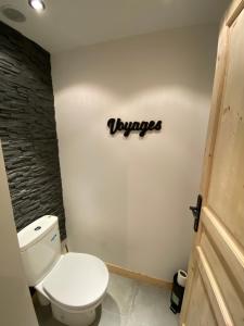 a bathroom with a toilet and a sign on the wall at Chambre privée in Villiers-en-Bière