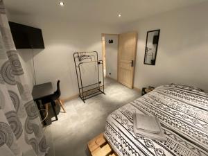 1 dormitorio con cama, escritorio y espejo en Chambre privée, en Villiers-en-Bière