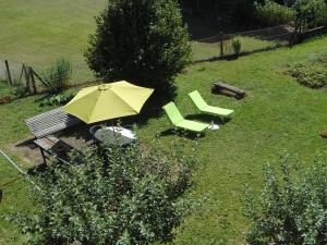 an umbrella and two chairs and a bench in a yard at Meublé de tourisme in Frasne