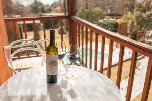 - une bouteille de vin assise sur une table avec deux verres dans l'établissement Postales Green Aparts - Chacras de Coria, à Chacras de Coria