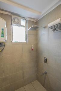 a bathroom with a shower with a window at Hotel Konark Inn in Indore