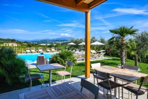 a patio with tables and chairs next to a pool at Locanda Corte Montioni in Lazise