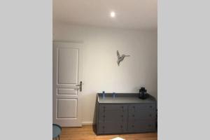 1 dormitorio con vestidor y puerta con un pájaro en la pared en Maison bord de Mer, en Bernières-sur-Mer 9 fotos más