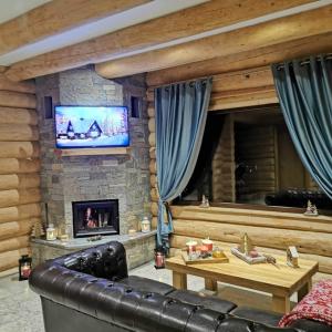 a living room with a couch and a fireplace at Cabana Livada in Borşa