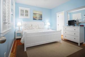 - une chambre avec un lit blanc et des murs bleus dans l'établissement Driftwood Bella Beach, à Depoe Bay