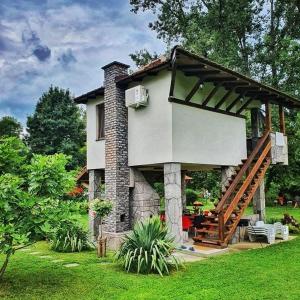 a house with a staircase in a yard at Drinska laguna in Banja Koviljača