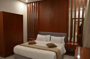 1 dormitorio con 1 cama grande con almohadas blancas en سماية للأجنحة الفندقية, en Riad