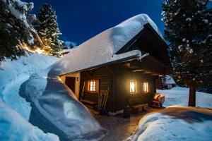 eine Hütte mit Schnee in der Nacht in der Unterkunft Almhaus Falkertzeit in Koflach