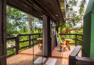 una terraza de madera con mesa y sillas. en Sunset Strip Eco Apartments, en Florianópolis