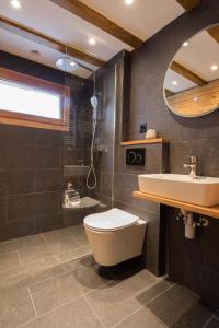 a bathroom with a toilet, sink, and bathtub at Chalet Tannegg in Saas-Fee