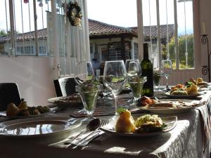 uma mesa com pratos de comida e copos de vinho em Posada Rural Villa Rouse em Guachantivá