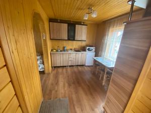 a kitchen with wooden cabinets and a table in a room at Міні Котедж in Verkhovyna