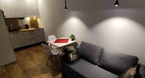 a living room with a couch and a small table at Ozas Green Apartment in Vilnius +5 photos