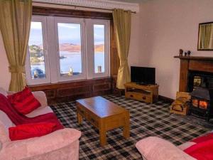 a living room with a couch and a fireplace at McCaig's Tower Apartment in Oban