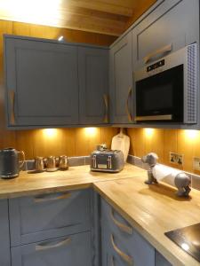una cucina con piano di lavoro e forno a microonde di Wildcat Lodge a Boat of Garten Altre 4 foto