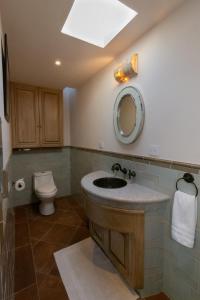 W łazience znajduje się umywalka, toaleta i lustro. w obiekcie Las Terrazas w mieście San Miguel de Allende