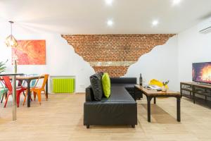sala de estar con sofá y pared de ladrillo en Ever House - IFEMA Canillas, en Madrid
