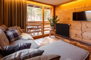 a living room with a couch and a flat screen tv at Chalet Tannegg in Saas-Fee