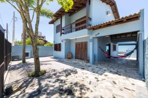 a house on the beach with a hammock outside at Casa Patta - 05 dormitórios, com piscina. in Bombinhas
