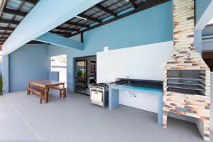 a kitchen with a wooden table and a stove at Casa Patta - 05 dormitórios, com piscina. in Bombinhas