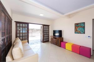a living room with a couch and a television at Casa Patta - 05 dormitórios, com piscina. in Bombinhas