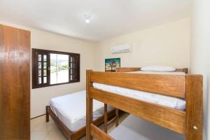 a bedroom with two bunk beds and a window at Casa Patta - 05 dormitórios, com piscina. in Bombinhas +23 photos