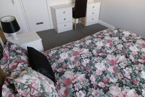 a bedroom with a bed with a floral blanket at Wonderland Guest House in Coventry