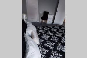 Wonderland Guest House في كوفينتري: غرفة نوم بسرير وسجادة بيضاء وسوداء
