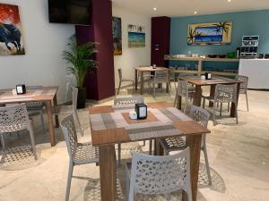 a dining room with wooden tables and chairs at Hotel Luma by Kavia in Cancún