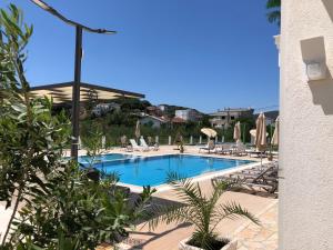 a swimming pool with lounge chairs and umbrellas at "HOLIDAY" apartments & rooms in Ulcinj