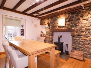 a dining room with a wooden table and a stone fireplace at Dunollie House in Inverness