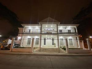 グアヤキルにあるWHITE HOUSEの夜の灯りを持つ大きな白い家