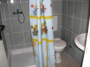 a bathroom with a toilet and a shower curtain at Apartments Odalović in Bijela