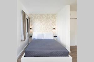 ein Schlafzimmer mit einem Bett mit Kissen in der Unterkunft Modern Studio on I-Drive: parking + pool included in Orlando