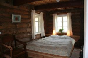 a bedroom with a bed and two windows at Miškiniškės in Ignalina