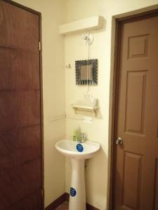 Un baño con un lavabo blanco y un espejo. en CASA ICHIK ANTIGUA GUATEMALA, en Antigua Guatemala