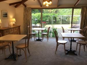 a room with tables and chairs and a window at Woodland Glen Lodge B&B in Hokitika