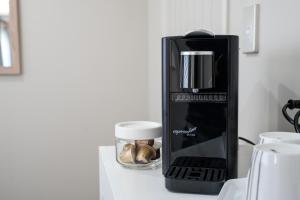 a black coffee maker sitting on a counter with a cup at Ambience on Pacific B&B in Palmerston North