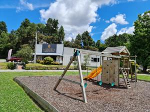 um parque infantil com um escorrega em frente a um edifício em Grandeur Thermal Spa Resort em Taupo