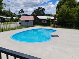 a swimming pool in a yard with a fence at Grandeur Thermal Spa Resort in Taupo