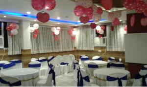 コルカタにあるDiamond Plazaの白と青の椅子と風船が備わる宴会場