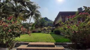 a yard with palm trees and a building at Anandvan Holiday Homes, Wai in Wai